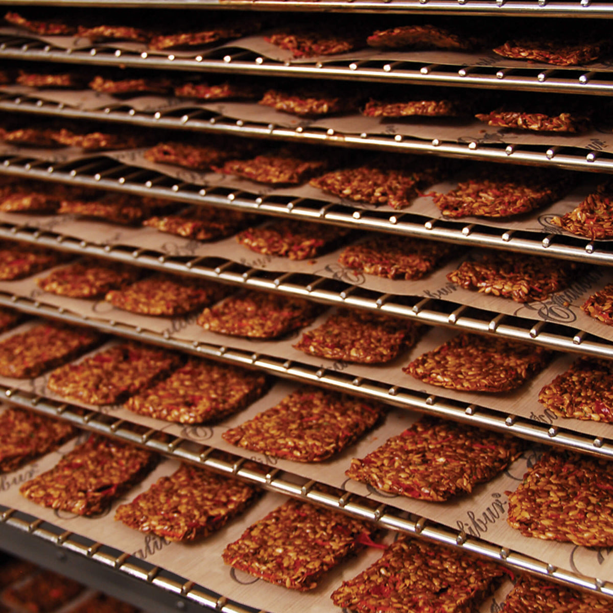 Excalibur COMM2 42 tray stainless steel commercial digital dehydrator with food on the trays.