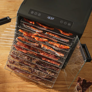 Excalibur DH10SC dehydrator on a bench with clear doors open and trays loaded with meat.