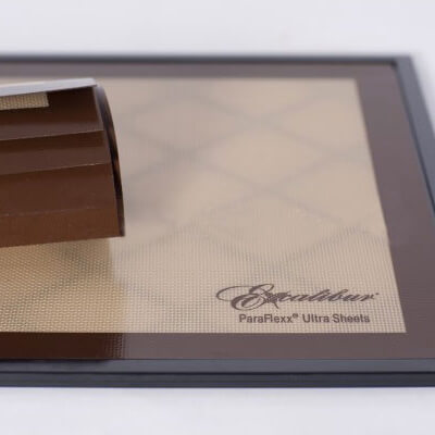 Excalibur Paraflexx Ultra silicone dehydrator drying sheet on a tray with a roll of sheets placed on top.