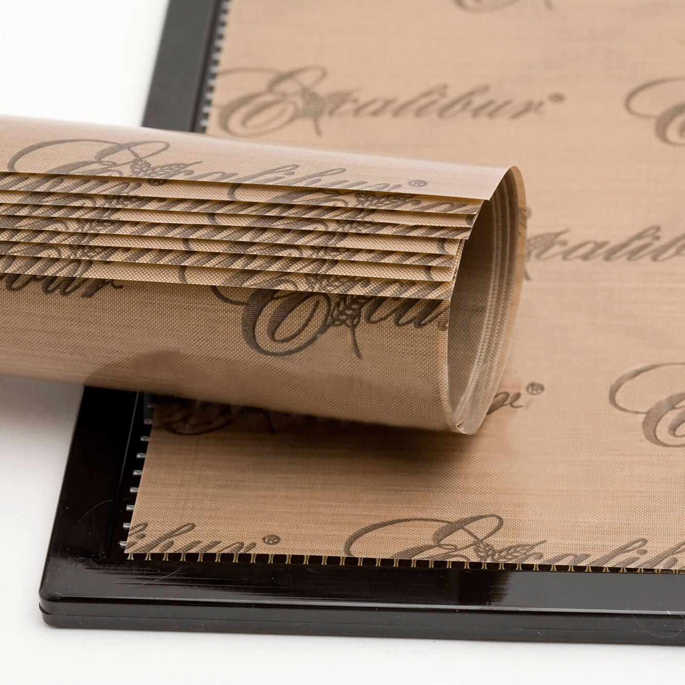 Excalibur ParaFlexx Premium teflon dehydrator drying sheet on a tray with a roll of sheets placed on top.