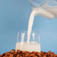 Living Synergy nut milk bag with glass of nut milk.